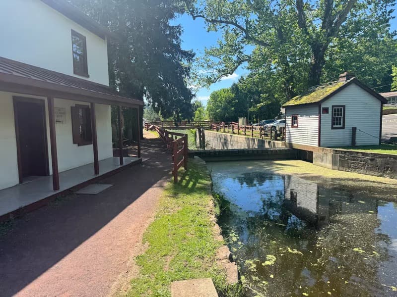 Main St Hideaway — the white clapboard building at 137 South Main with the wooden lockhouse, canal, and towpath visible from the back patio.