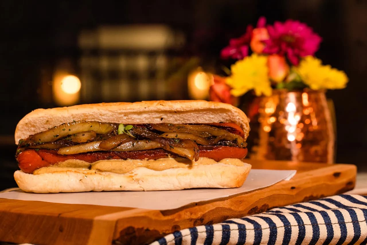 Dam Dog — a long house dog on a soft roll with grilled peppers and onions.