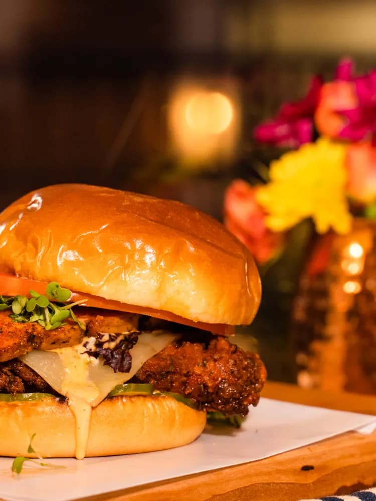 A chef-driven burger at The Burgerly in New Hope, PA, photographed warm on a live-edge wood board.